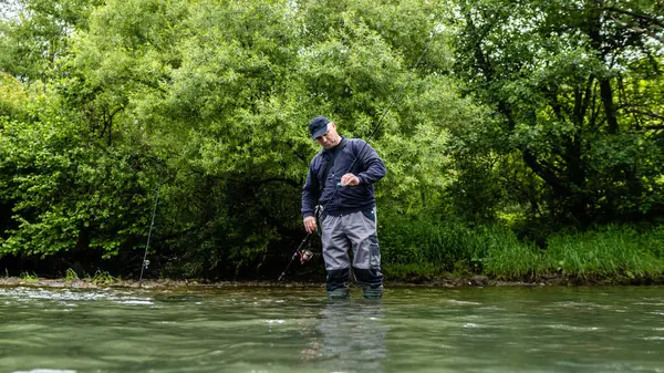 Erkekler yazın nehir kenarında balık tutmayı severler.