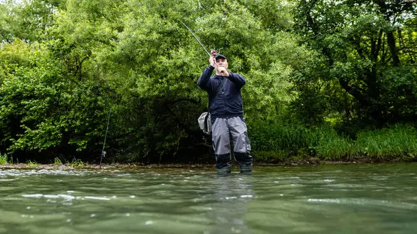 Erkekler yazın nehir kenarında balık tutmayı severler.