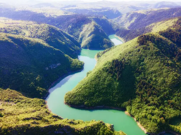 Yazın nehir ve dağların havadan görünüşü. Kentsel olmayan bir yer. Güneşli bir gün