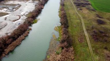 Kuşlar uçarken insansız hava aracı Bega 'nın nehir kıyısındaki kuru sazlıklara doğru iniyor.