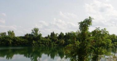 Güneşli bir günde bulutlu küçük bir gölün zaman akışı