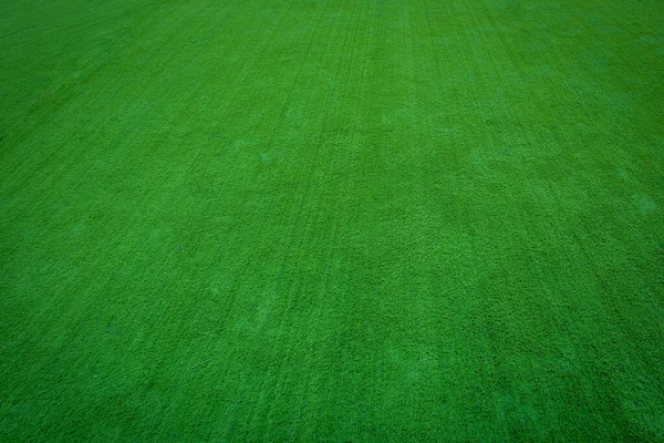 Astroturf rulosu ya da çimenlik arazi paspası suni çim futbol sahası, yeşil çimen arka plan.