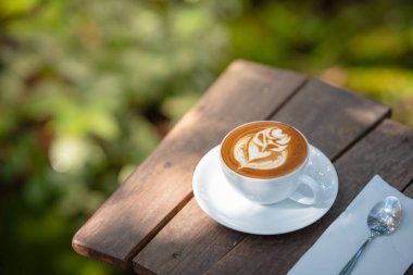 Sıcak sanat sütlü kahve. Arka plan kahve fincanı ve fasulye. Eski mutfak masasında..