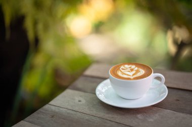 Sıcak sanat sütlü kahve. Arka plan kahve fincanı ve fasulye. Eski mutfak masasında..