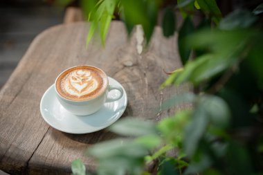 Sıcak sanat sütlü kahve. Arka plan kahve fincanı ve fasulye. Eski mutfak masasında..