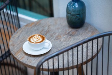 Sıcak sanat sütlü kahve. Arka plan kahve fincanı ve fasulye. Eski mutfak masasında..