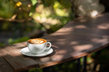 Sıcak sanat sütlü kahve. Arka plan kahve fincanı ve fasulye. Eski mutfak masasında..