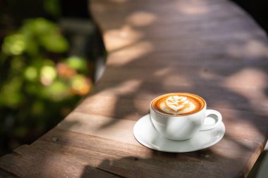 Sıcak sanat sütlü kahve. Arka plan kahve fincanı ve fasulye. Eski mutfak masasında..