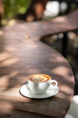 Sıcak sanat sütlü kahve. Arka plan kahve fincanı ve fasulye. Eski mutfak masasında..