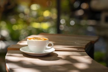 Sıcak sanat sütlü kahve. Arka plan kahve fincanı ve fasulye. Eski mutfak masasında..