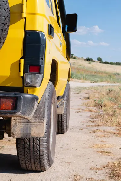 Close-up of a yellow off-road vehicle on a country road