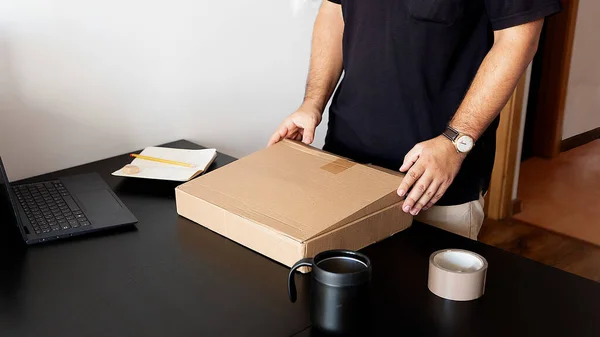 A worker packing a box to ship
