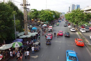 Bangkok Road with tuktuk, cars and a market directly next to the street with little traffic. High quality photo