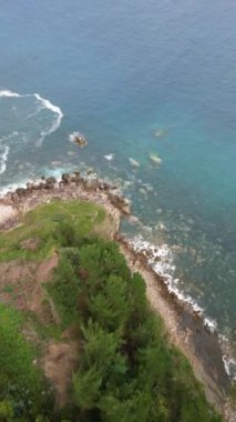 Kuzey İspanya 'daki Atlantik Okyanusu' nun kıyısında dalgalar kırılıyor ve arkada harika bir orman var. Yüksek kalite 4k görüntü