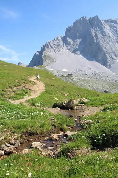 Küçük nehri olan yürüyüş yolu ve arkada kadın yürüyüşçüsü, Küçük Pamuk ile birlikte SAC Carschina İsviçre Wanderer sezonuna giden yol. Yüksek kalite fotoğraf