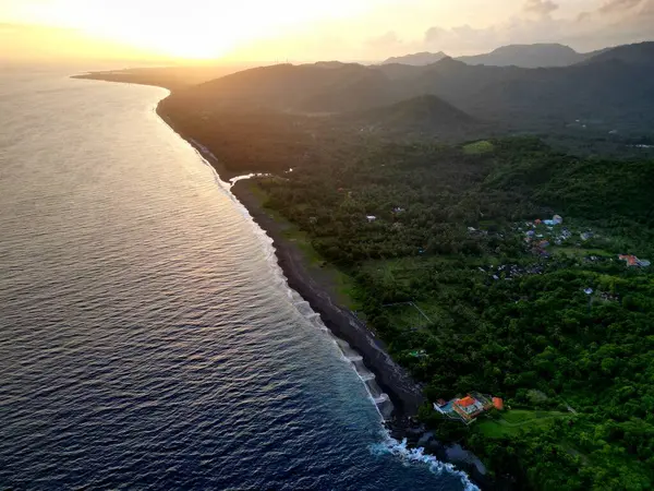 Klungkung Bölgesindeki Okyanus Dalgaları ile Blacksand Plajı 'nın Hava Görüntüsü. Orman ve Tepeler arkada, günbatımında. Yüksek kalite fotoğraf