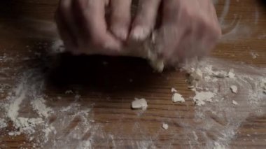 Bir kız masada çıplak elleriyle hamur yoğurur. Hamur yoğurmak. Yemek hamuru. Pişirme çizelgeleri