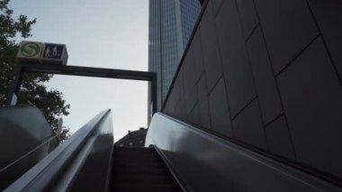 Metro 'dan iş yerine kadar yürüyen merdivenden çıkın, modern binalara bakın.