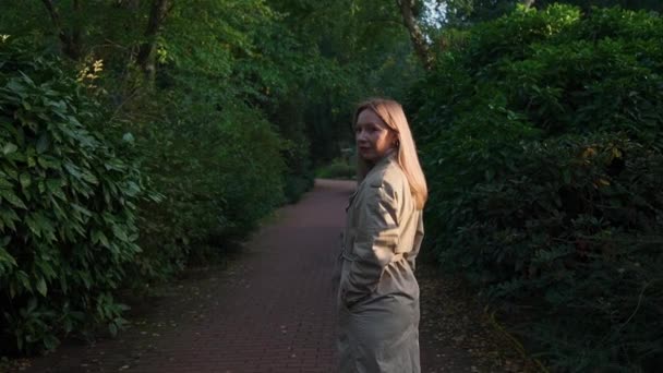 Žena Parku Stojí Bokem Světle Barevném Plášti Kamera Běží Dopředu — Stock video