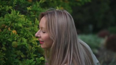 Kadın çalılıktaki mandalina meyvesine faiziyle bakıyor. Açık renkli ceketli sarışın bir kadın. Yüzünde neşe vardı. Mandalina çalıları