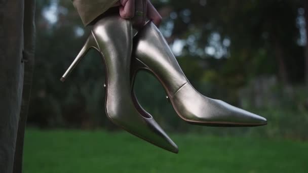 Eine Frau Hält Schuhe Der Hand Aus Nächster Nähe Goldfarbene — Stockvideo