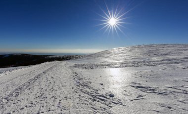 Güneş ve mavi gökyüzü ile güzel bir kış manzarası.
