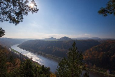 Gün batımında kayalar ve ormanlarla kaplı bir manzara. Dağın tepesinden bak.