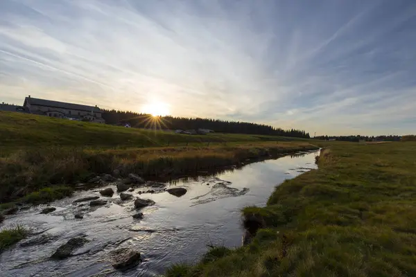 Çek kırsalında akan küçük bir nehrin üzerinde gün batımı.