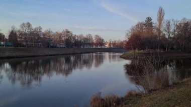 Şehrin içinden akan bir nehir manzarası ve onu çevreleyen ağaçlar.