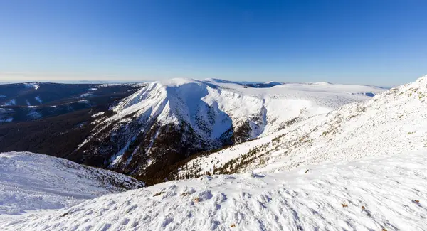 Kar ve açık mavi gökyüzü ile kış dağı manzarası. Panoramik manzara. Dev dağlar..