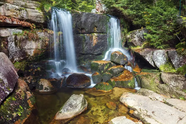Dağ vadisinde küçük bir şelale manzarası.