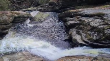 Bir dağ vadisinde güzel bir şelale manzarası.