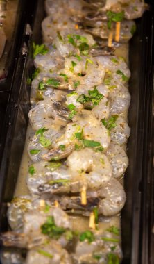 Markette marine edilmiş karides şişleri.