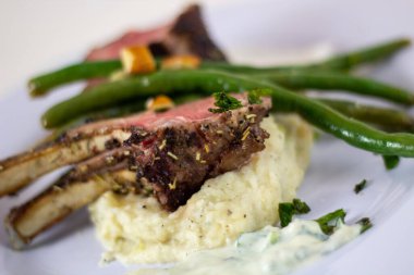 Patates püresi ve yeşil fasulyeli Fransız kuzu çevirin.