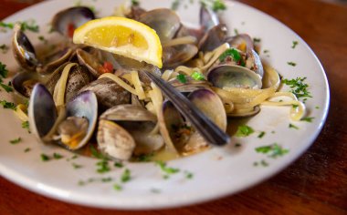 Limon ve maydanozla süslenmiş tereyağı soslu makarna.