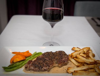 Sebze ve patates kızartmalı biftek ve şarap.