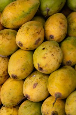 Meyve pazarında satılık bir yığın sarı mango.