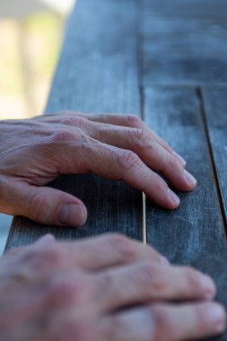 İnsanların elleri masanın üstünde, ilgilenilmeyi bekliyor.