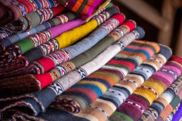 Peruvian table runners or scarves stacked for sale
