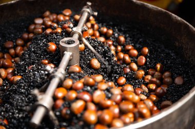 Atıştırmak için kömürde kestane çevirme