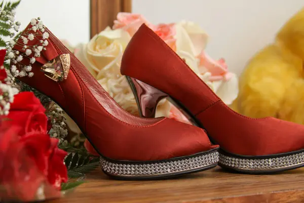 Red heels and bouquet for a wedding