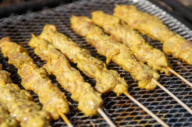 Izgaradaki tavuk satay kızartılıyor.