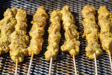 Izgaradaki tavuk satay kızartılıyor.