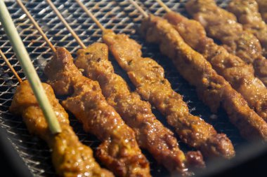 Izgaradaki tavuk satay kızartılıyor.