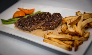 Sebzeli ve baharatlı biftek ve patates kızartması.