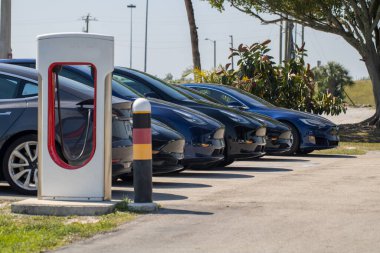 Dinlenme tesisinde elektrikli arabalar şarj ediliyor.