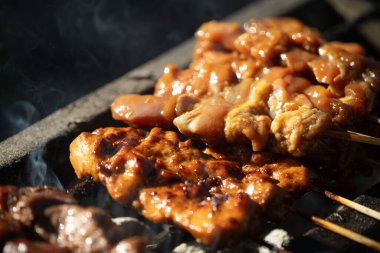 Izgaradaki satay mangal kömürüyle pişiriliyor.