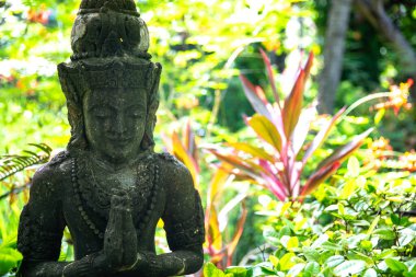 Bahçesinde yemyeşil bitkiler olan bir balerin heykeli