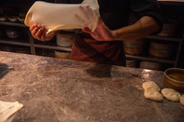 Şef yardımcısı roti canai ya da paratha hazırlıyor.