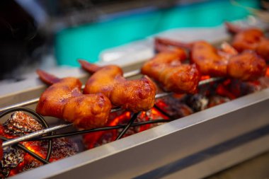 Sokak yemekleri için sıcak kömürlerde tavuk kanadı pişiriyorum.